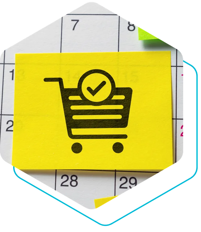 Gelber Notizzettel mit Einkaufswagen-Symbol auf einem Kalender