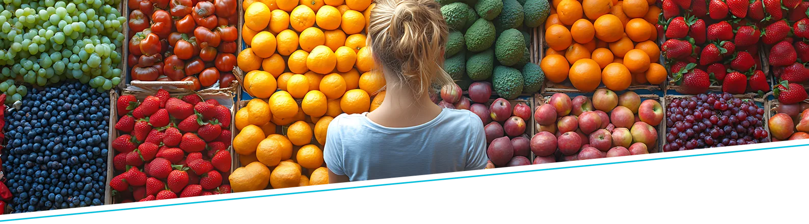 Frische Obst- und Gemüseauslage, eine Kundin steht davor